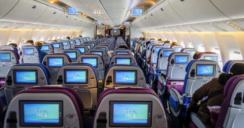 Airplane interior filled with seats, illustrating the best seating arrangements for families traveling with children.
