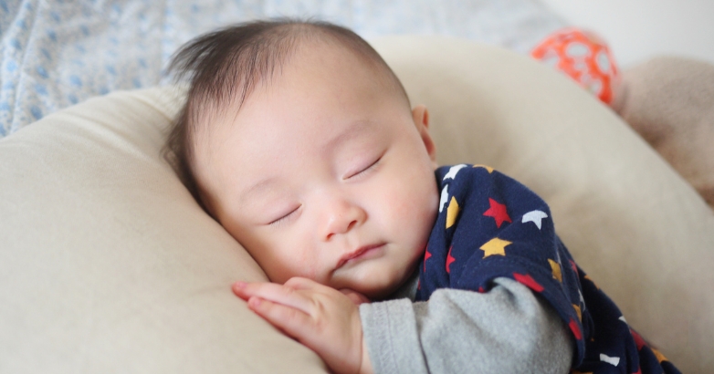 A sleeping baby on a pillow, highlighting strategies for families to manage children's sleep during air travel.